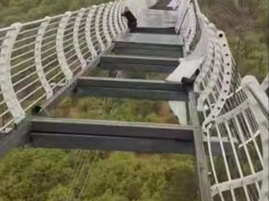 Кошмар наяву: в Китаї турист застряг на висоті 100 метрів, коли під ним почав валитися скляний міст